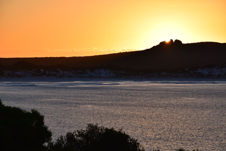 Serene sunrise over Cape Le Grand, capturing tranquil waters and golden hues.