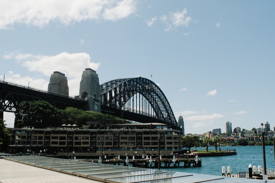 Iconic Sydney Harbour Bridge against a blue sky with the city skyline.