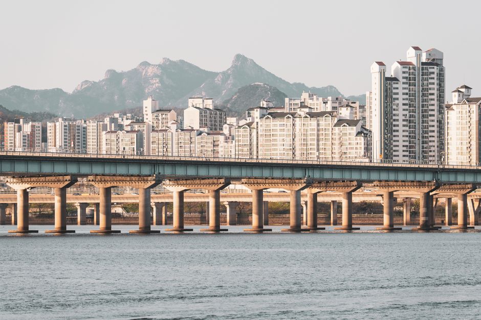 Scenic view of modern Seoul skyline with a bridge crossing the Han River and mountains in 