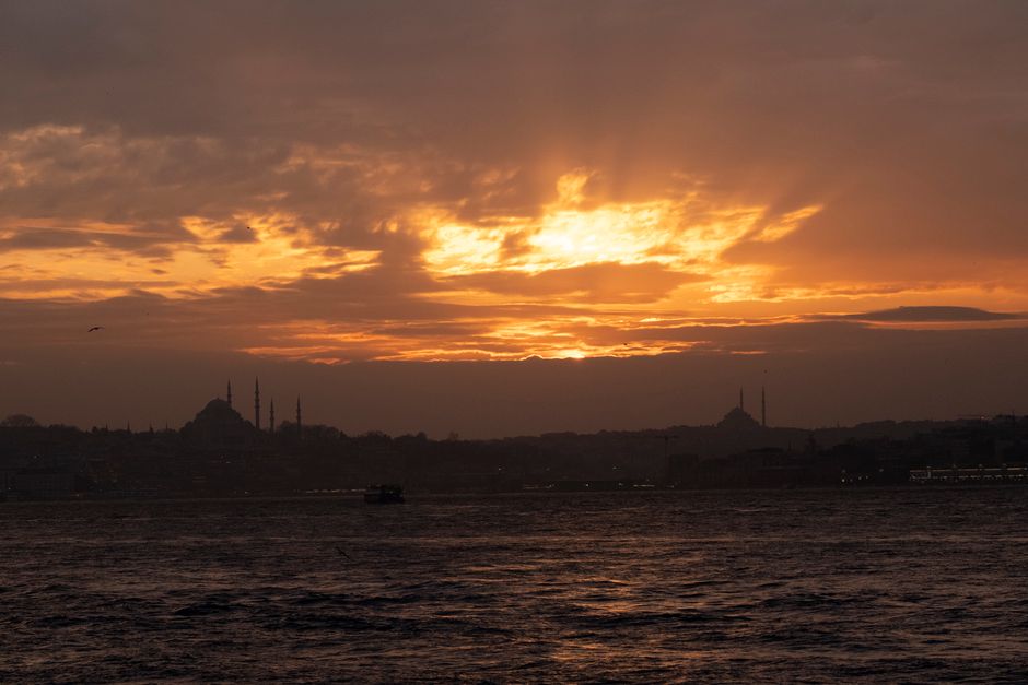 Stunning sunset view with silhouettes of Istanbul's iconic mosques against a vibrant sky.
