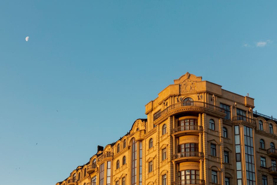 A beautiful architectural shot of a Baku building against a twilight sky with the moon visible.