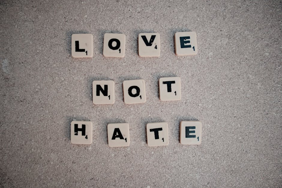 Scrabble tiles on pavement spelling the inspirational message 'Love Not Hate'.